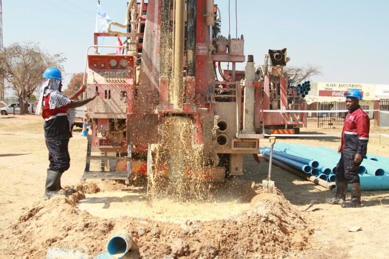 Workers drill a borehole at the launch ceremony of a China-aided borehole drilling project in Mahusekwa, a town in Mashonaland East Province