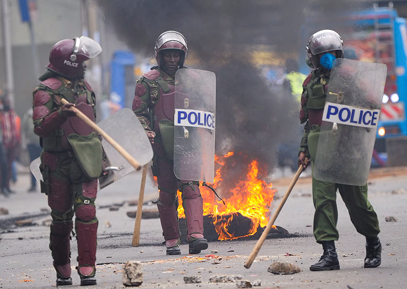 Riot police officers walk to disperse protestors during an anti-government demonstration, following nationwide deadly riots over tax hikes and a controversial now-withdrawn finance bill, in Nairobi