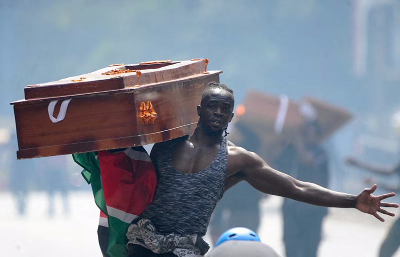 A protester carries a casket during a demonstration over police killings of people protesting against the imposition of tax hikes by the government, in Nairobi, Kenya