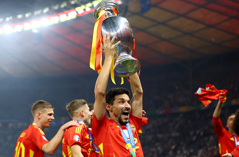 Spain's Jesus Navas celebrates with the trophy after winning the final