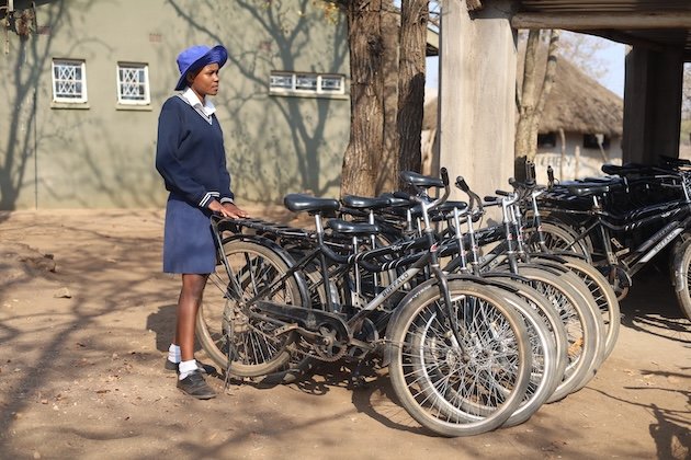 Rejoice Muzamani with some of the bicycles girls ride at Mwenje Primary School in Chiredzi, Zimbabwe