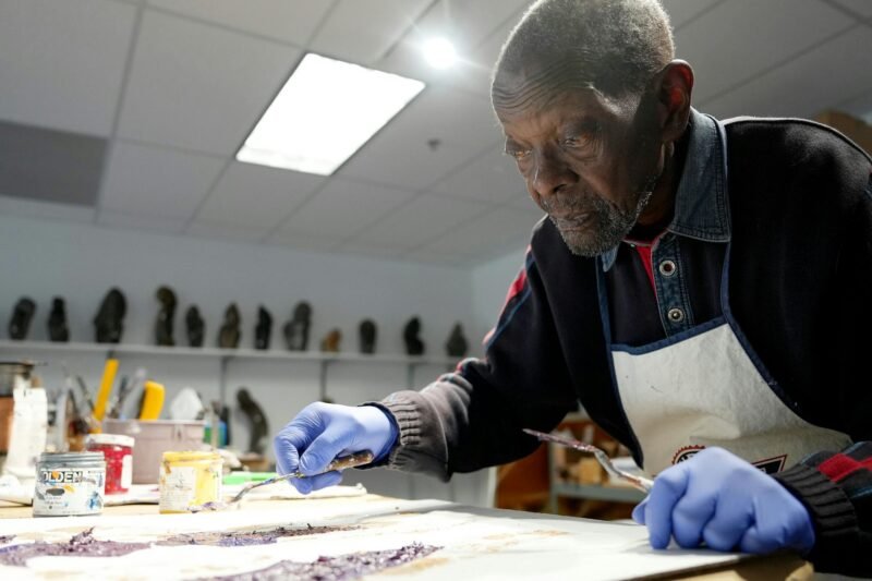 Mhiripiri mixes excess paints at his studio on the second floor of the gallery.