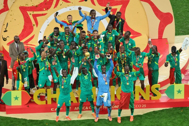 Senegal’s Sadio Mane holds the trophy aloft as he celebrates with teammates after winning the Africa Cup of Nations final soccer match between Senegal and Morocco in Rabat, Morocco