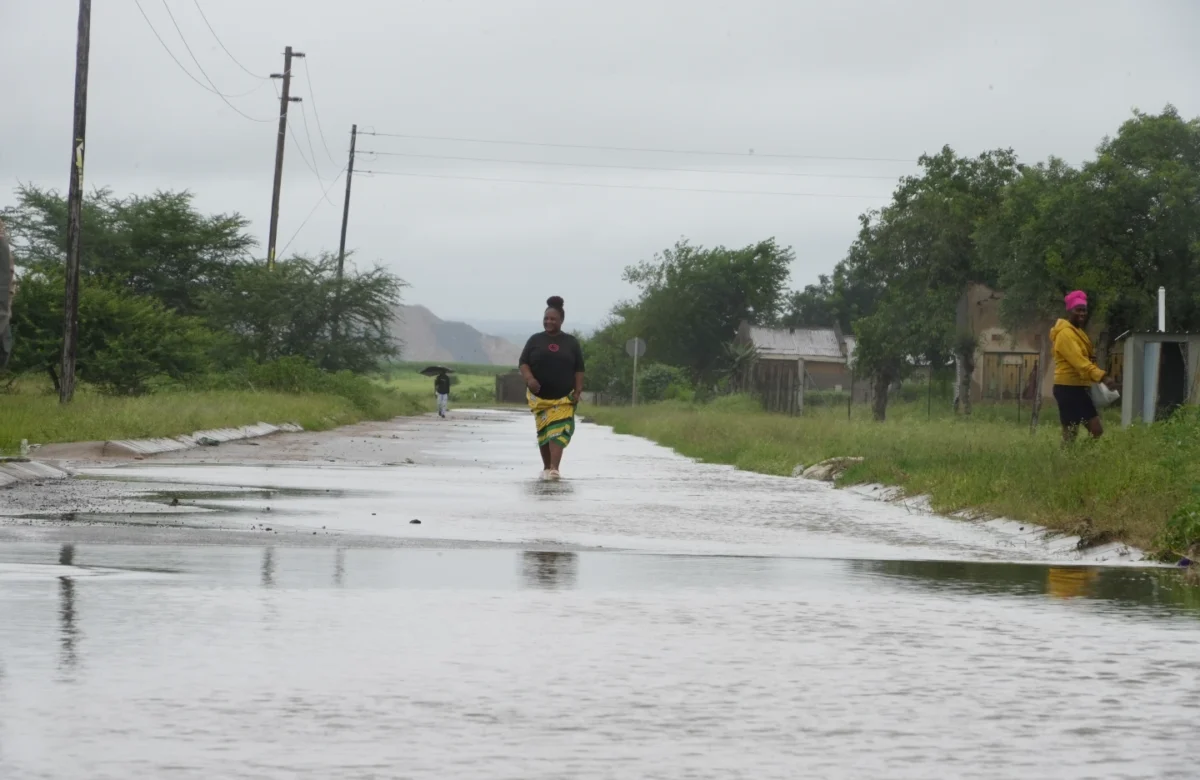 People walk through floodwaters in Nkomazi, Mpumalanga Province, South Africa, on Friday